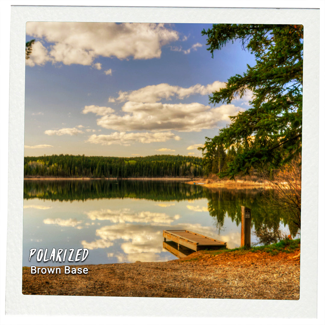 Lake reflection with a small dock and clear blue sky.