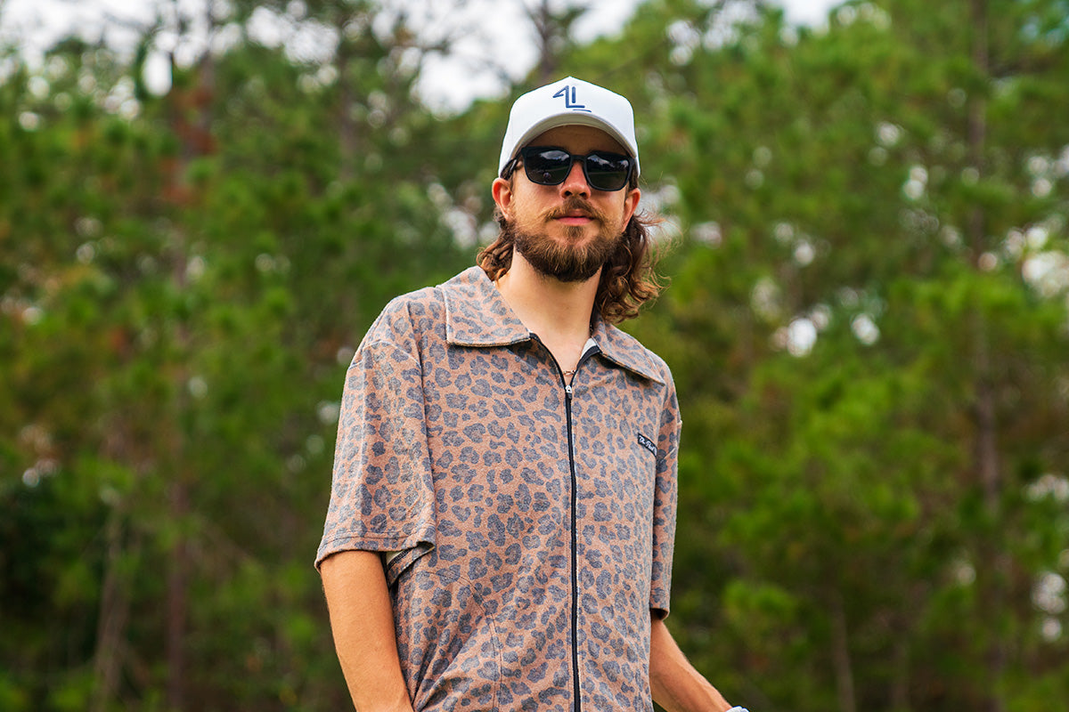 Snowboarder carving through powder in snowy terrain.